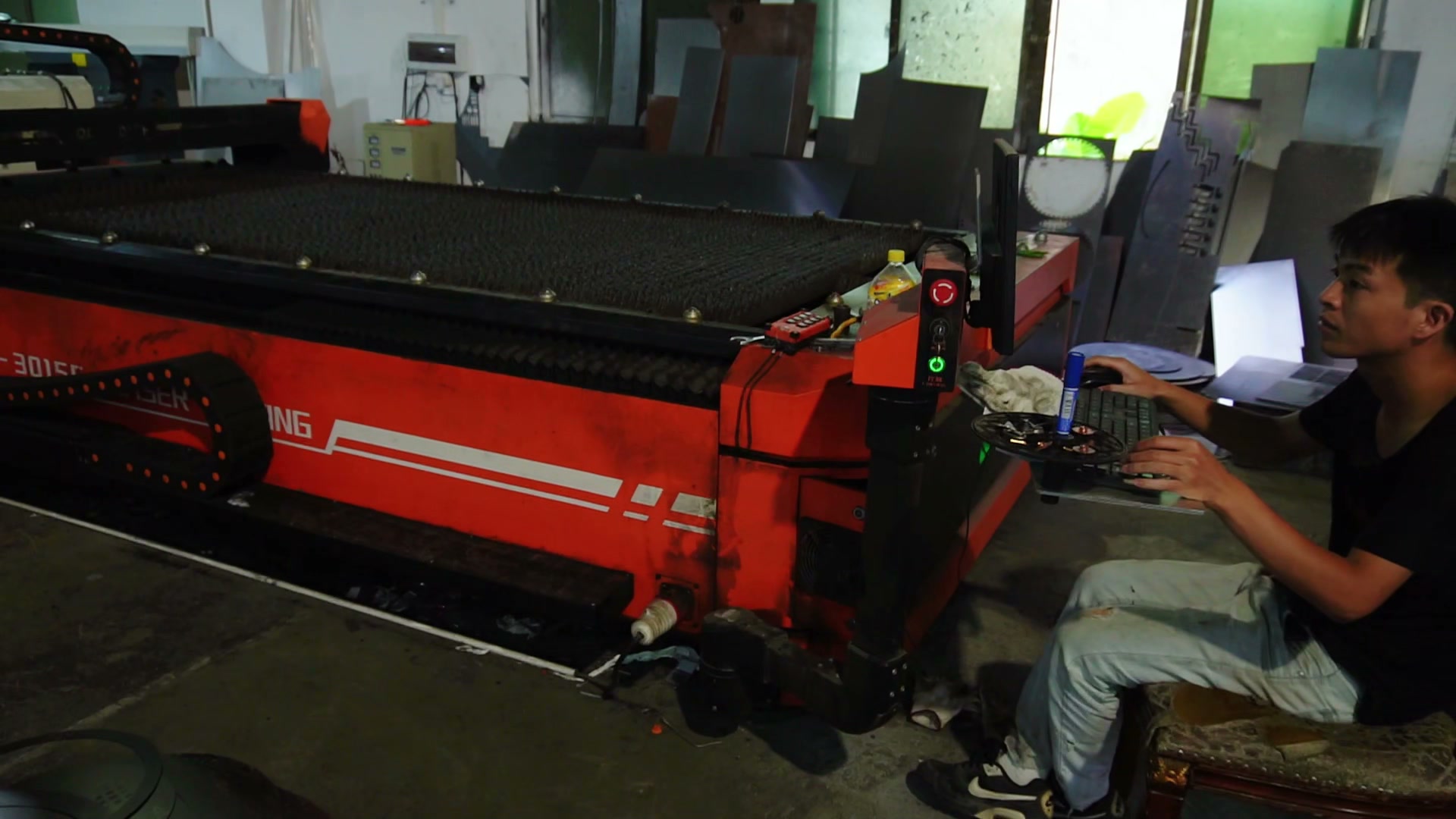 Operator seated beside a flat-bed cutting machine