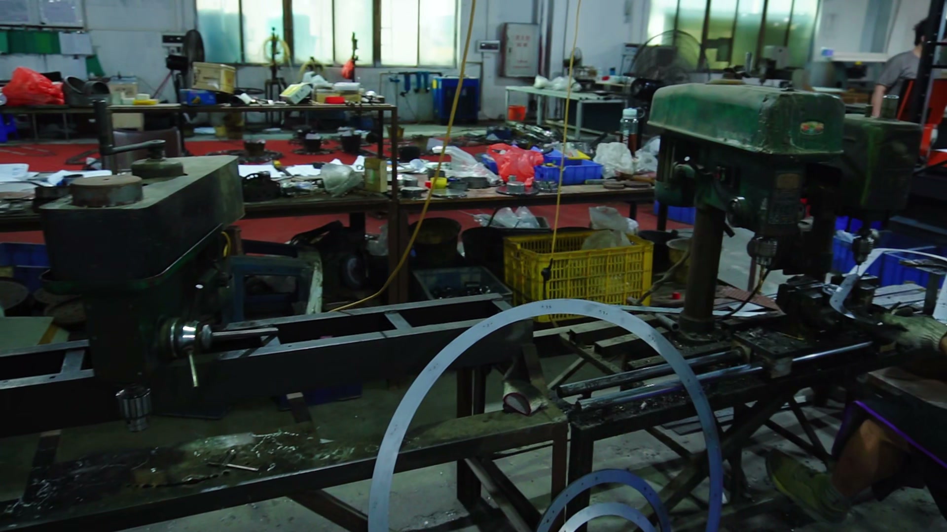 Curved metal strip beside a forming machine