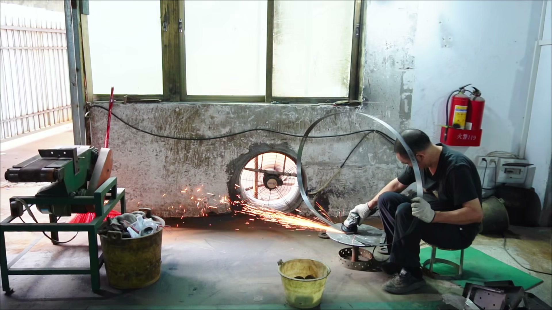 Worker grinding a metal ring with visible sparks