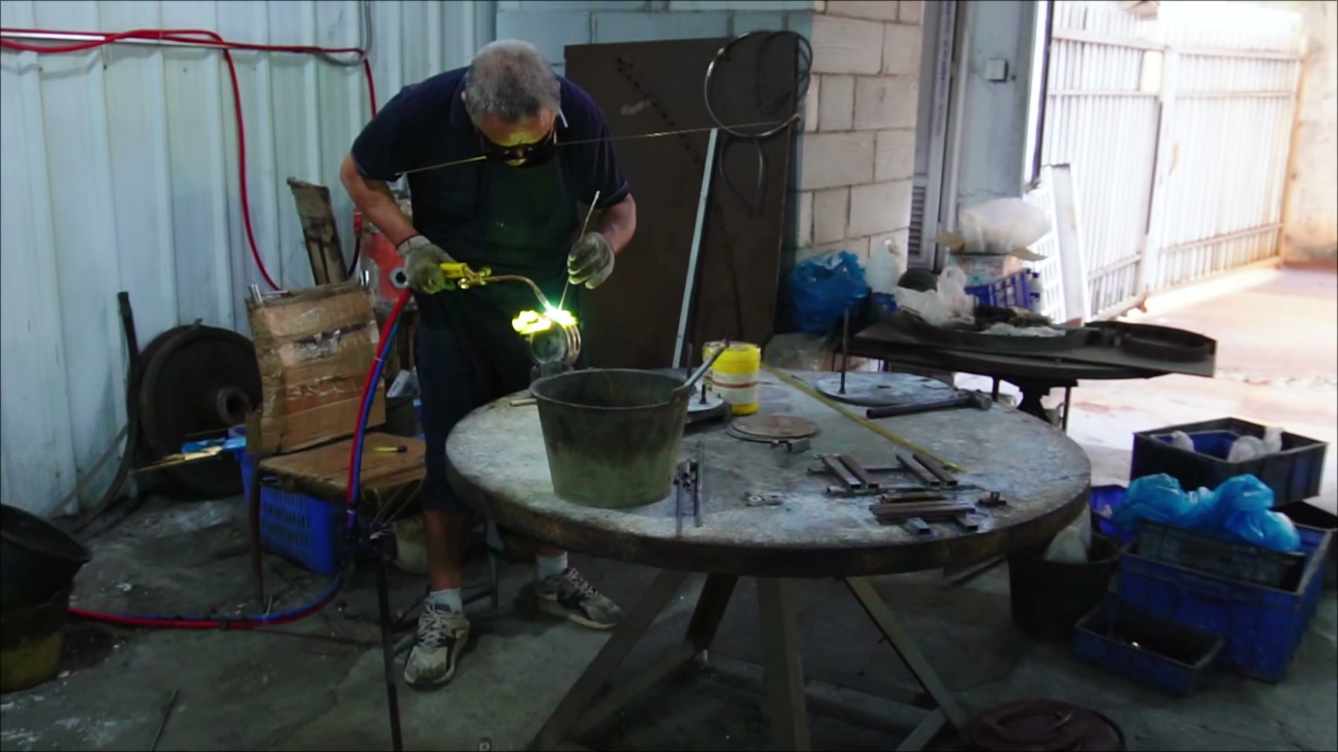 Worker joining a metal component with a torch flame