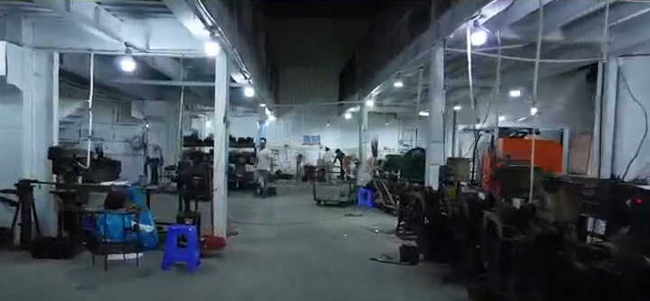 Small subtitle-free frame showing a workshop aisle