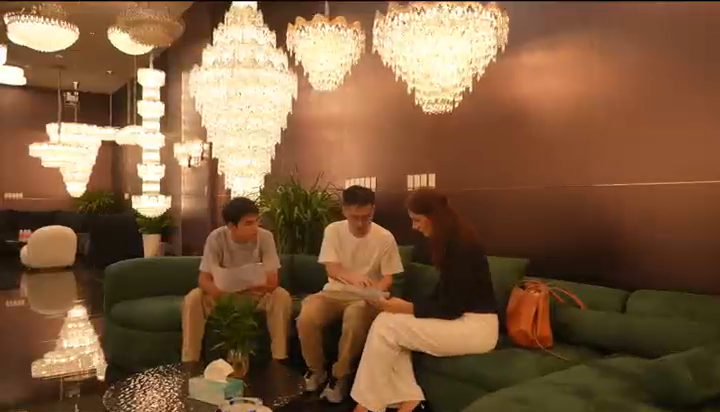 Ivan and visitors discussing lighting in person beneath decorative chandeliers
